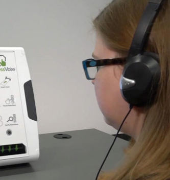 A voter uses headphones and audio