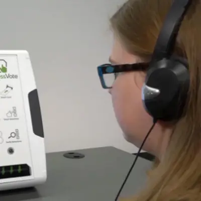 A voter uses headphones and audio